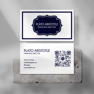 May include: Two white business cards with navy blue text and design elements. The top card features a navy blue ornate frame with the text "PLATO ARISTOTLE MANAGING DIRECTOR." The bottom card includes contact information and a QR code.