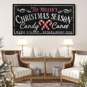 May include: A black and white sign with red and white candy canes. The sign reads "The Miller's Christmas Season Candy Canes Hand Rolled Established 2022".