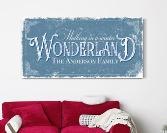 May include: A blue and white vintage-style sign with the text "Walking in a winter WONDERLAND THE ANDERSON FAMILY". The sign has a distressed, textured look and is framed with a decorative border.
