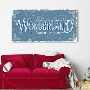 May include: A blue and white vintage-style sign with the text "Walking in a winter WONDERLAND THE ANDERSON FAMILY". The sign has a distressed, textured look and is framed with a decorative border.