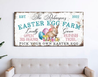 May include: A rustic sign with the text "The Robinsons Easter Egg Farm" in blue and pink lettering. The sign also includes the text "EST. 2022", "Locally Grown", "Open All Hours", "Bunny Trail", and "Pick Your Own Easter Egg". The sign is decorated with a watercolor illustration of a bunny rabbit and Easter eggs.