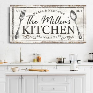 May include: White wooden sign with distressed paint and black text that reads "EST. 2023 Meals & Memories The Miller's Kitchen Are Made Here". The sign features a vintage fork and spoon graphic.