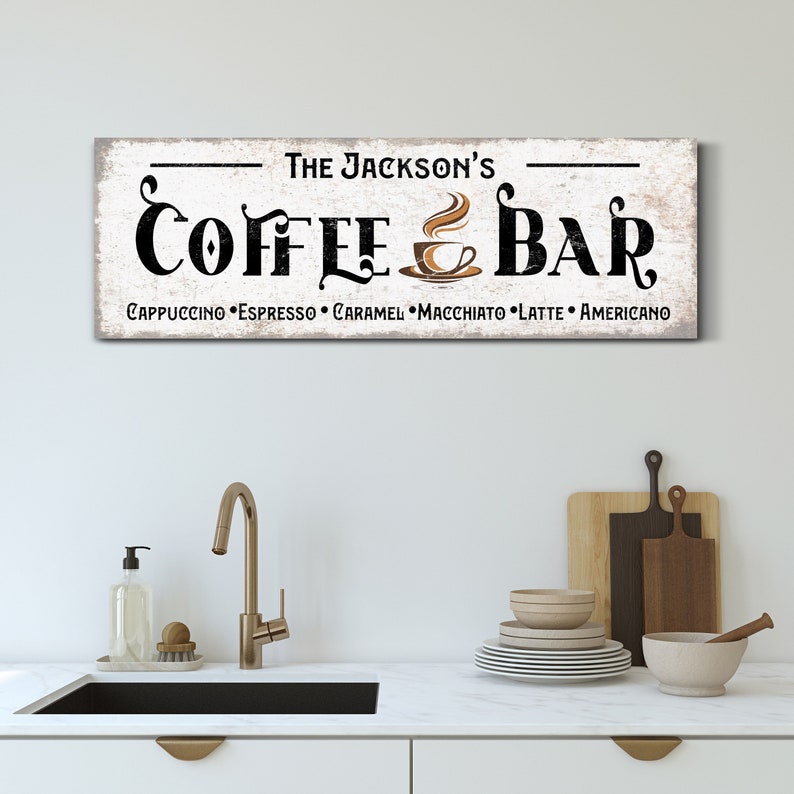 May include: A white wooden sign with black text that reads "The Jackson's Coffee Bar" with a stylised coffee cup and steam design. The sign also lists the coffee drinks offered: Cappuccino, Espresso, Caramel, Macchiato, Latte, Americano.
