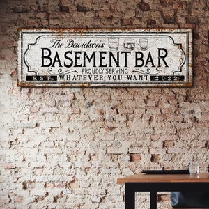 May include: A white sign with black text and a rusty border reads "The Davidson's Basement Bar Proudly Serving Whatever You Want Est 2022". Three white silhouettes of glasses are above the word "Bar".