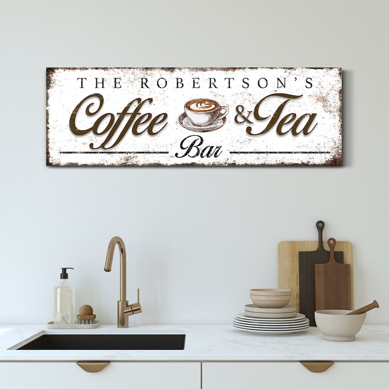 May include: A rectangular wooden sign with the text "THE ROBERTSON'S Coffee & Tea Bar" in brown and black lettering. The sign features a coffee cup illustration and a distressed white background.