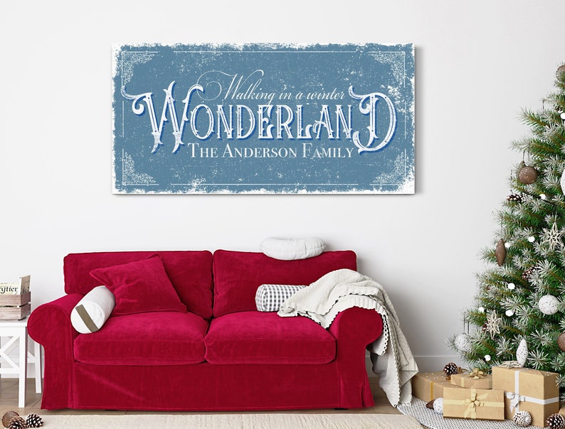 May include: A blue and white vintage-style sign with the text "Walking in a winter WONDERLAND THE ANDERSON FAMILY". The sign has a distressed, textured look and is framed with a decorative border.