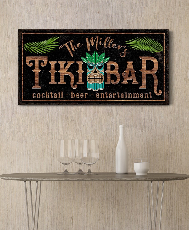 May include: A black and brown wooden sign with the text "The Millers Tiki Bar" and the words "cocktail, beer, entertainment" below. The sign features a green and blue tiki head with a carved wooden face.