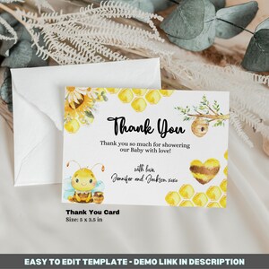 May include: A thank you card with a bee and honeycomb design. The card is white with yellow and brown accents. The text on the card reads "Thank You" and "Thank you so much for showering our Baby with love! with love, Jennifer and Jackson xoxo". The card also includes the text "Thank You Card Size: 5 x 3.5 in".
