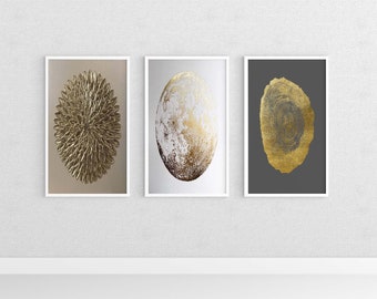 May include: Three framed prints with gold leaf designs. The first print features a circular design with a gold leaf texture. The second print features a gold leaf oval design on a white background. The third print features a gold leaf tree ring design on a dark grey background.