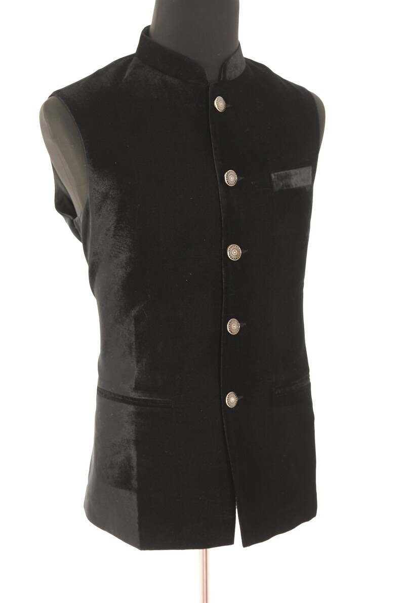 May include: A black velvet waistcoat with a mandarin collar and silver buttons.