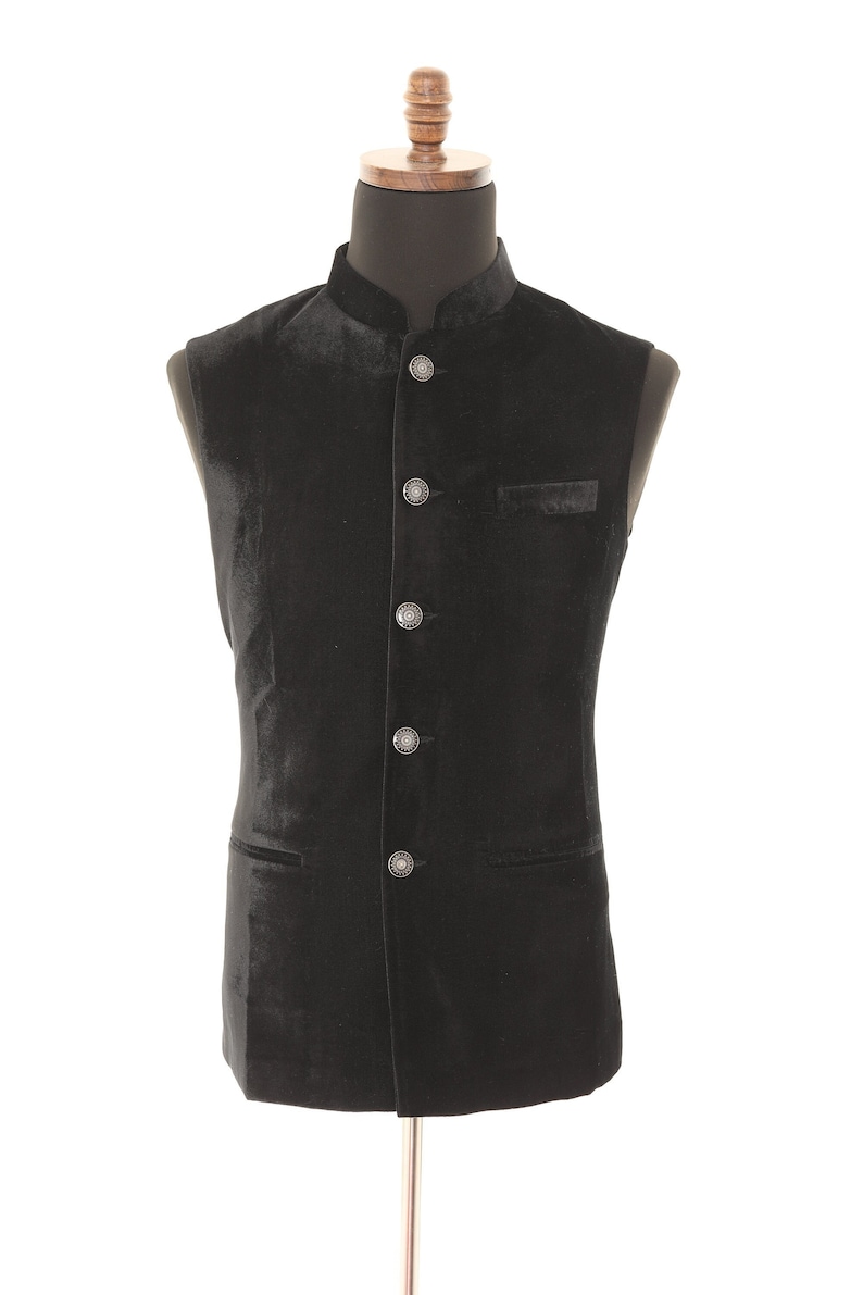 May include: A black velvet waistcoat with a mandarin collar and silver buttons.