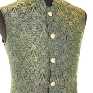 K&ouml;nnte beinhalten: Eine gr&uuml;ne Weste mit einem goldenen Paisley-Muster und goldenen Kn&ouml;pfen. Die Weste ist aus Brokatstoff.