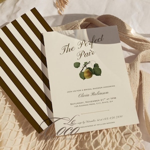 May include: Bridal shower invitation with the text "The Perfect Pair" and a pear illustration. The invitation is cream-colored with black text and a brown and white striped design on the back. The invitation includes the date, time, and location.