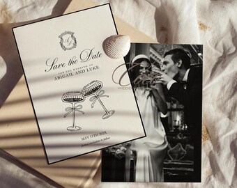 May include: Save the Date card with black text on a cream background. The card features a monogram with the letters A and L, two champagne glasses, and the text "Save the Date for the wedding of Abigail and Luke, May 11th 202X".