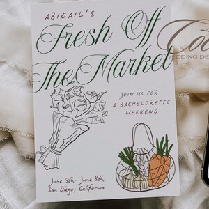 May include: A white card with black and green calligraphy that reads "Abigail's Fresh Off The Market" and "Join us for a Bachelorette Weekend". The card also features a black and white illustration of a bouquet of flowers and a black and white illustration of a mesh bag filled with carrots, garlic, and green onions. The text "June 5th-June 8th San Diego, California" is written in black ink.