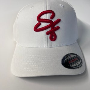 May include: White baseball cap with a red embroidered "SF" logo. The cap has a Flexfit label on the back with the text "The Original Flexfit L/XL It Fits Your Life."