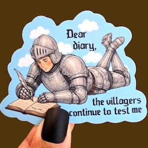 Puede incluir: Una pegatina troquelada que muestra a un caballero con armadura de placas plateada tumbado boca abajo sobre un cielo azul claro con nubes blancas. El caballero escribe en un libro abierto con una pluma. Texto: Dear diary, the villagers continue to test me.