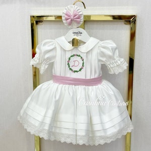 Vestido Amy. Vestido de niña de flores con lazo rosa hasta la rodilla y mangas globo blancas. Vestido de niña bordado con letras con nombre