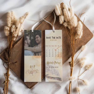 Può includere: Un set di due segnalibri salva la data con un tema di Harry Potter. Il segnalibro di sinistra presenta una foto di una coppia e il testo "HIP". Il segnalibro di destra ha un calendario con la data "28 maggio 2020" cerchiata e il testo "Hazell & Percy Si sposano".