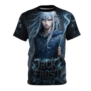 Peut inclure: T-shirt noir avec une illustration détaillée d'un personnage à la peau pâle, aux yeux bleus et aux longs cheveux blancs. Le personnage porte une veste à capuche bleue et tient un bâton. Le texte "JACK FROST" est affiché en police gothique.