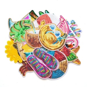 May include: A collection of colorful sequined patches in various shapes, including a sun, palm leaf, coconut drink, flip-flops, and a flamingo. The patches feature bright colors and are likely for decorative purposes.