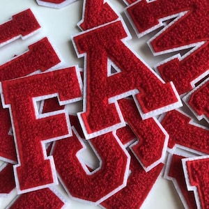 Op de afbeelding: Rode vilt letters met witte randen. De letters spellen "FUN" uit.