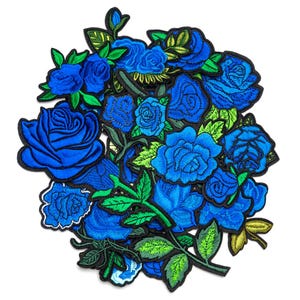 Op de afbeelding: Een verzameling geborduurde blauwe rozenpatches met groene bladeren en zwarte contouren. De patches variëren in grootte en rozenontwerp, waardoor een gelaagde bloemenarrangement ontstaat. Geschikt voor kleding en knutselprojecten.