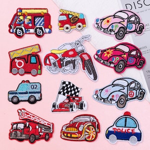 May include: A set of ten iron-on patches featuring various vehicles, including a red fire engine, a motorcycle, a blue police car, a red racing car, and several Volkswagen Beetles. The patches are all colourful and detailed, and they would be perfect for adding a touch of personality to clothing, bags, or other items.