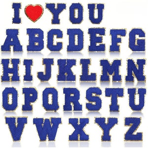 Op de afbeelding: Een verzameling blauwe stoffen letters, inclusief de zin "I ❤️ YOU", met gouden rand. Het rode hart staat tussen de letters "I" en "YOU". De letters zijn in een vette blokstijl.