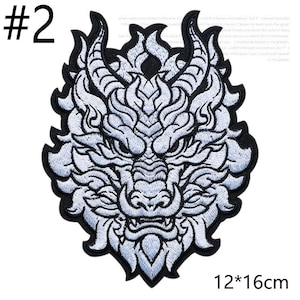 May include: Embroidered patch featuring a detailed white dragon head design with black outlining. The patch is approximately 4.7 x 6.3 inches and has the number "2" in the upper left corner.