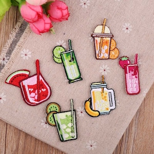 May include: Six embroidered iron-on patches featuring various colorful drinks with straws and fruit accents. The patches include a watermelon drink, a green drink with a lime wedge, a yellow drink with a lemon wedge, a pink drink with a strawberry, a yellow drink with a lemon wedge in a mason jar, and a yellow drink with a lemon wedge in a plastic cup.