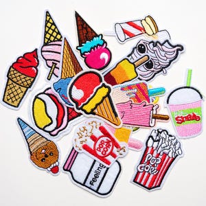 May include: A collection of colorful embroidered patches featuring ice cream cones, popsicles, popcorn, and a milkshake. The patches have a white border and are in various colors, including red, pink, yellow, and brown.