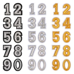 May include: A collection of embroidered number patches in various colors: black and silver, silver, and gold. Each patch features a number from 1 to 0, with a white border. These patches are ideal for customizing apparel or accessories.