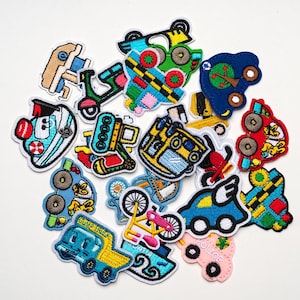Op de afbeelding: Een verzameling geborduurde patches met verschillende voertuigen. Ontwerpen omvatten auto's, vrachtwagens, scooters en fietsen in heldere kleuren zoals blauw, groen, rood en geel. Elke patch heeft een witte rand.