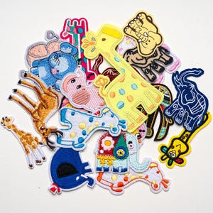 Può includere: Una collezione di toppe ricamate a tema animale. Le toppe presentano vari animali, tra cui giraffe, elefanti ed elefanti, con cuciture dettagliate e colori vivaci. Queste toppe sono ideali per decorare abbigliamento o accessori.