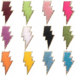May include: Twelve iron-on patches shaped like lightning bolts in a variety of colours, including pink, green, white, black, orange, and blue. Each patch has a gold outline.