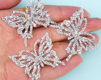May include: Three silver butterfly-shaped rhinestone embellishments. Each butterfly is made of small, sparkling rhinestones.