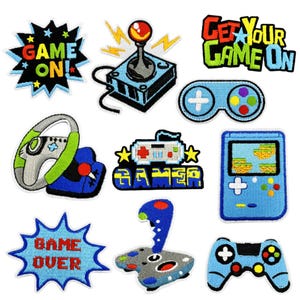 May include: A collection of embroidered patches with a gaming theme. Designs include a joystick, game controllers, a steering wheel, and phrases like "Game On!" and "Game Over." The patches feature bright colors like blue, green, red, and yellow.