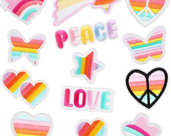 Könnte beinhalten: Ein Set mit 12 Bügelbildern mit Regenbogen-Designs. Die Patches beinhalten Herzen, Sterne, Schmetterlinge, Peace-Zeichen und die Wörter "LOVE" und "PEACE".