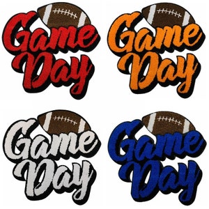 May include: Four different colored patches with the words "Game Day" and a football on top. The patches are red, orange, white, and blue.