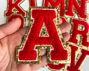 May include: Red felt letter A with a gold glitter outline. The letter is approximately 7.5 cm tall and is part of a set of letters.