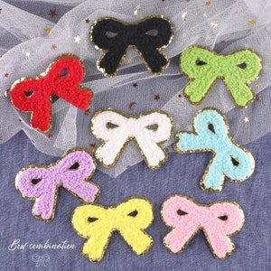 May include: Assortment of eight fuzzy bow-shaped fabric patches with gold glitter trim. The bows are in various colors, including red, black, green, white, purple, yellow, and pink.