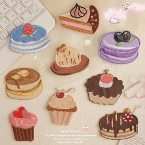May include: Ten embroidered iron-on patches featuring various desserts, including cakes, cupcakes, macarons, and pastries. The patches are colourful and detailed, with a variety of textures and designs.
