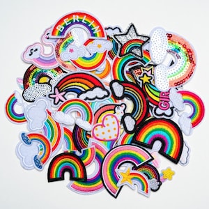 Peut inclure: Un ensemble de patchs arc-en-ciel brodés aux couleurs vives. Certains patchs comportent des nuages, des étoiles et le mot "Berlin". Les patchs sont de différentes formes et tailles, avec des couleurs vives comme le rouge, l'orange, le jaune, le vert, le bleu et le violet.