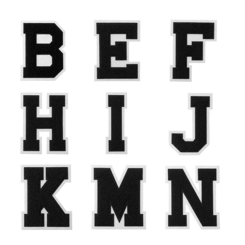 K&ouml;nnte beinhalten: Schwarze Filzbuchstaben des Alphabets, B, E, F, H, I, J, K, M und N. Die Buchstaben sind wei&szlig; umrandet und haben einen Vintage-Stil.