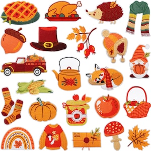 May include: A collection of embroidered patches featuring autumn-themed icons including a pie, roasted turkey, hedgehog, scarf, acorn, hat, berries, knit hat, gnome, truck, corn, teapot, fox, socks, pumpkin, jam jar, apple, basket, rainbow, sweater, envelope, mushroom, and leaf.