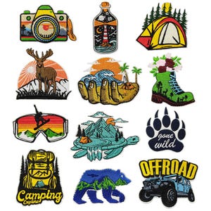 May include: Set of 12 embroidered iron-on patches featuring outdoor adventure themes. Patches include a camera, a bottle, a tent, a deer, a hand holding a wave, a hiking boot, a snowboarder, a turtle, a paw print, a backpack, a bear, and a jeep.