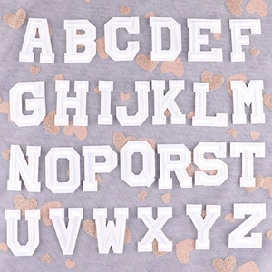 Parche termoadhesivo bordado con letras blancas, ideal para ropa, sombreros, bolsos y accesorios.