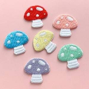 May include: Six embroidered iron-on patches of colorful mushrooms with white stems and white dots. The mushrooms are red, pink, yellow, blue, green, and purple.
