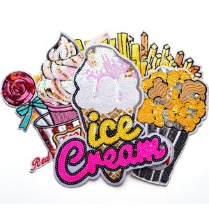 May include: A collection of sequined patches featuring ice cream, popcorn, a lollipop, and french fries. The ice cream patch has the words "ice cream" in yellow and pink. The patches are colorful and detailed.